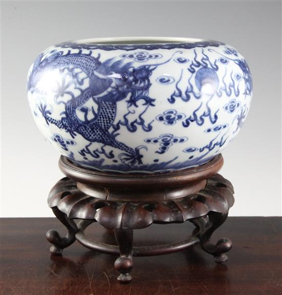 A Chinese blue and white dragon alms bowl, early 20th century, diameter 22cm, wood stand